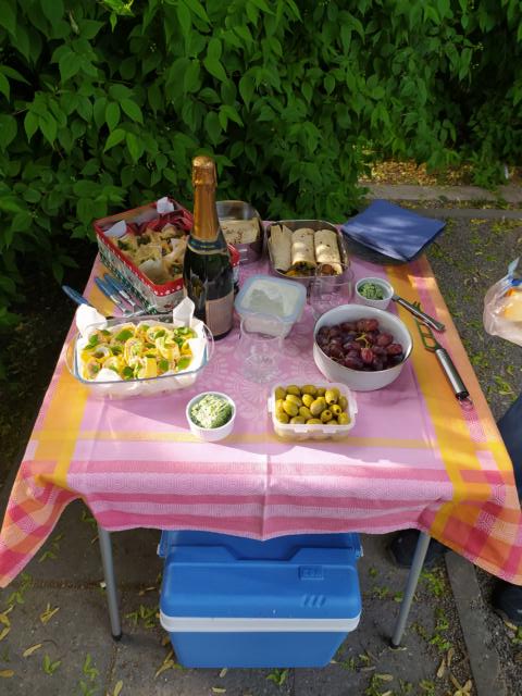 Schön gedeckter Camping-Tisch mit Sektflasche und Fingerfood.