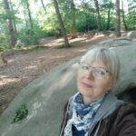 Frau vor großem Stein
