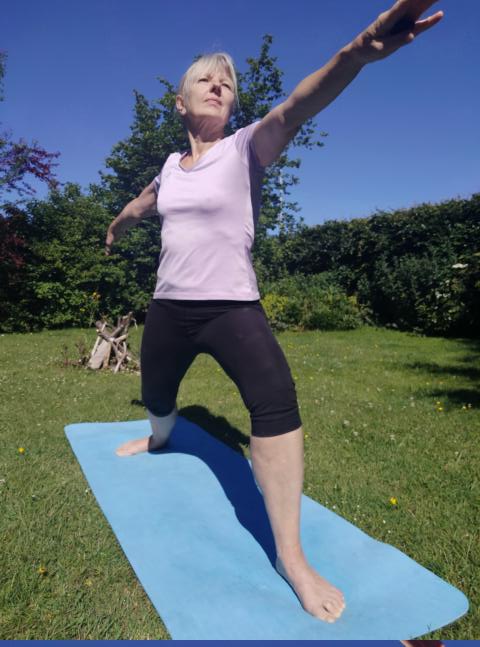 Frau macht Yoga-Übung Der Krieger im Garten