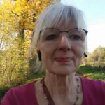 Frau mit Kopfhörern im Wald unterwegs