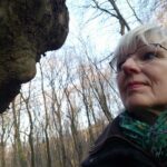 Frau im Portrait mit Blick auf einen wunderlichen Baumauswuchs