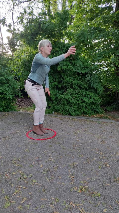 Boule spielende Frau, die gerade die Kugel geworfen hat.
