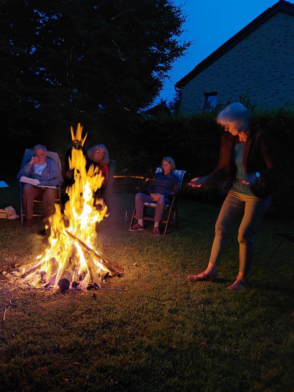 Frau macht Lagerfeuer im Garten